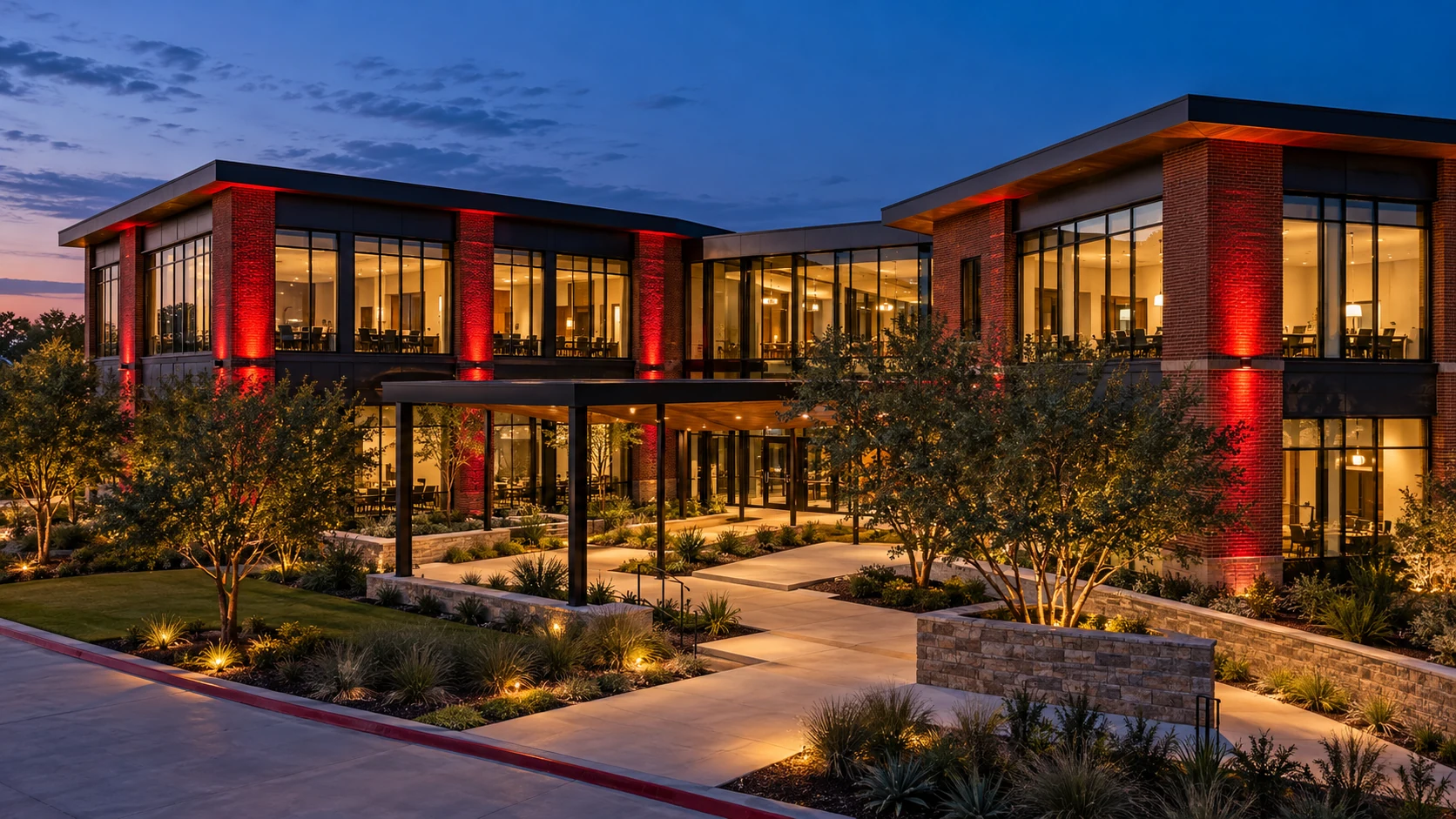 Brick and glass commercial office property with red accent lighting at dusk